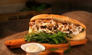 Delicious chicken sandwich with mayonnaise and greens served on a wooden board.